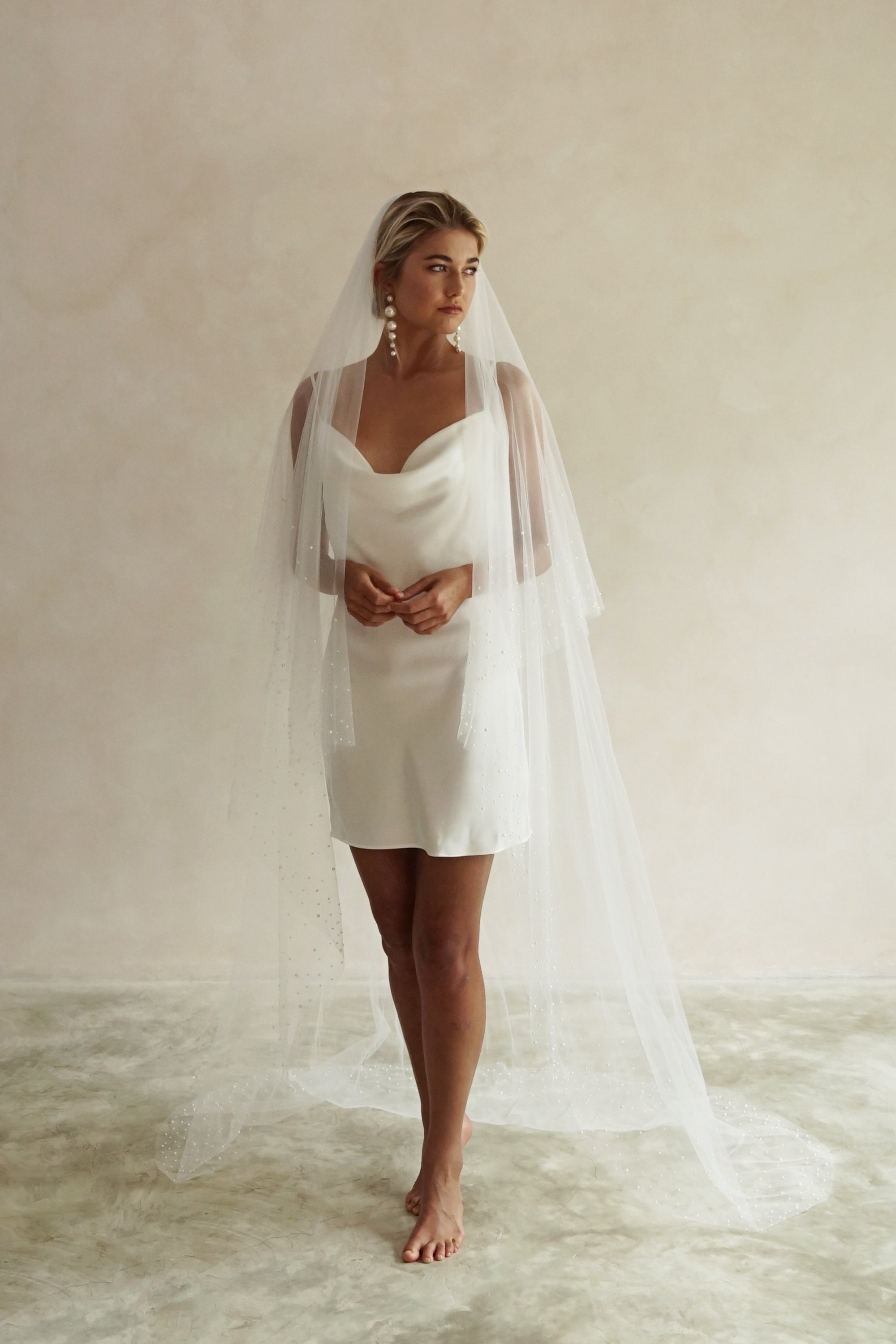 A model wearing ESTELLE, a two tier pearl wedding veil by Madame Tulle bridal