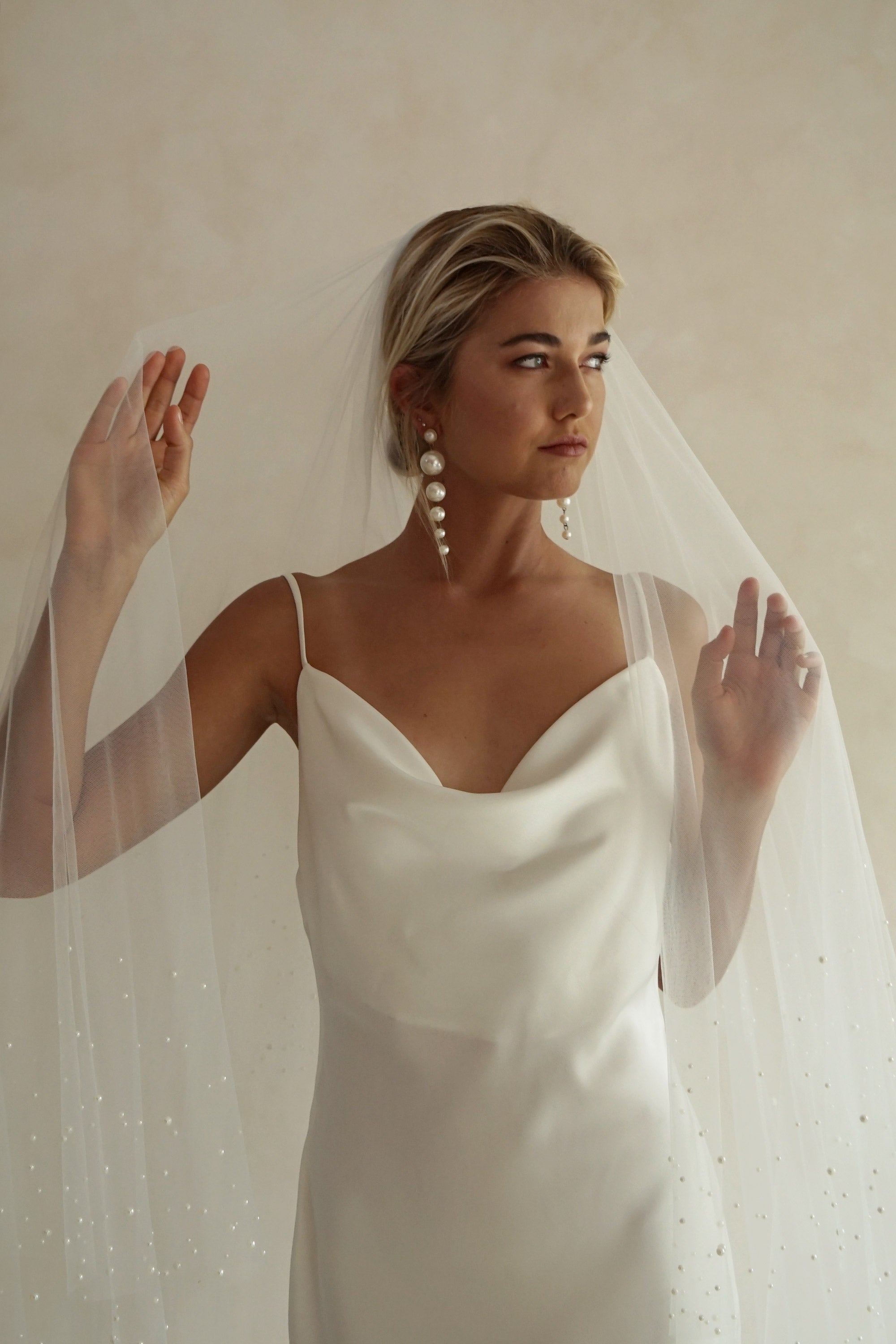 A model wearing ESTELLE, a two tier pearl wedding veil by Madame Tulle bridal