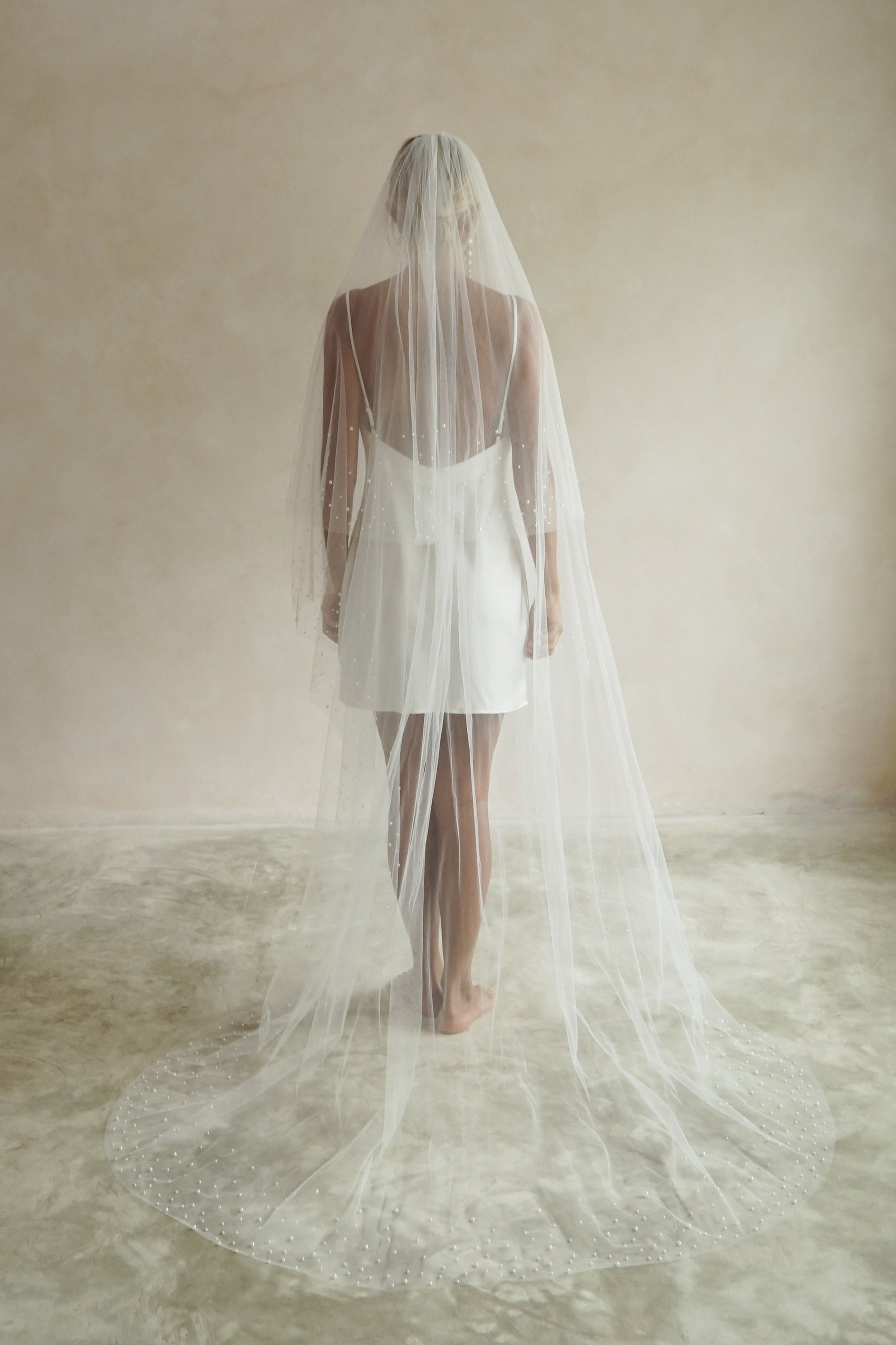 A model wearing ESTELLE, a two tier pearl wedding veil by Madame Tulle bridal