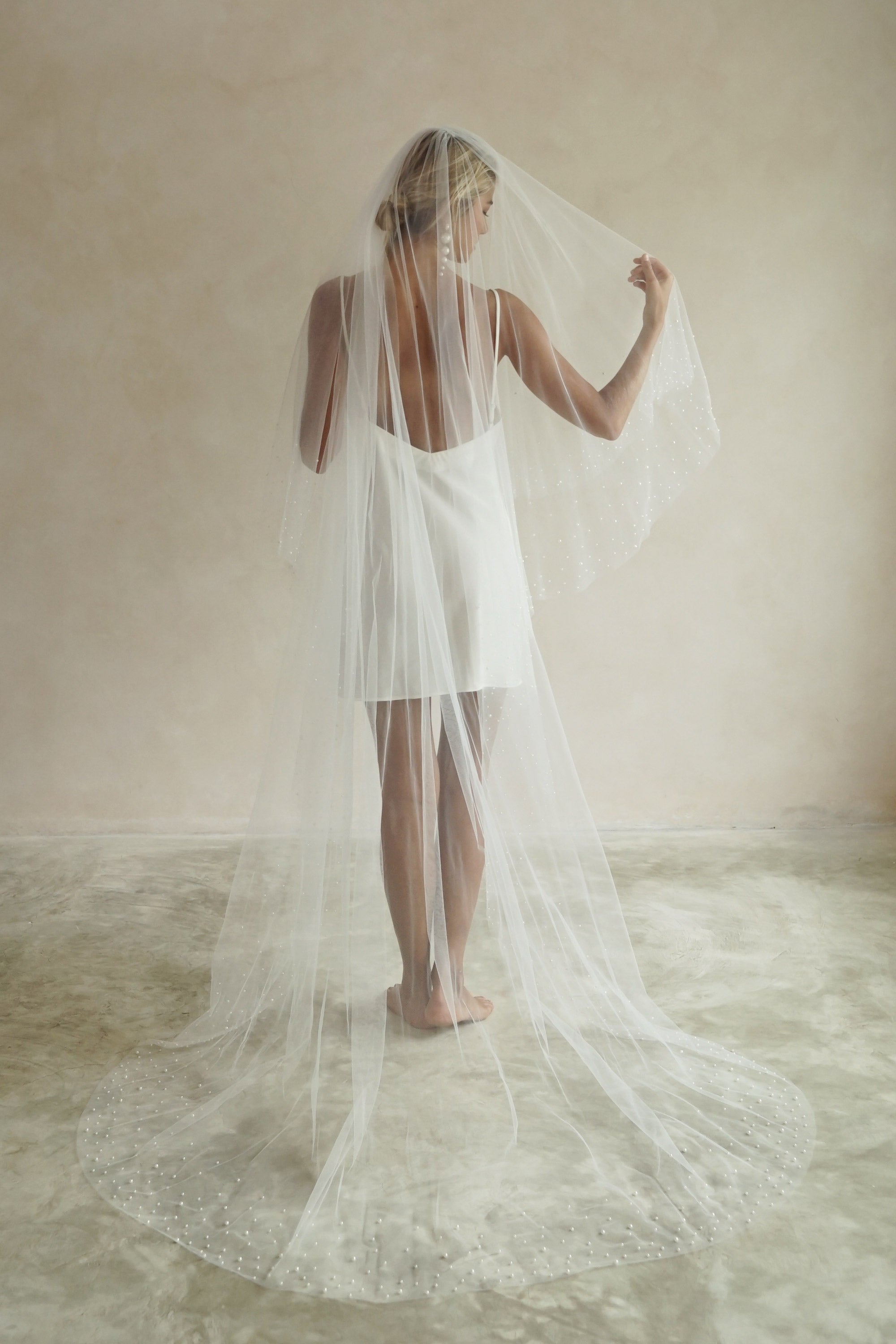 A model wearing ESTELLE, a two tier pearl wedding veil by Madame Tulle bridal