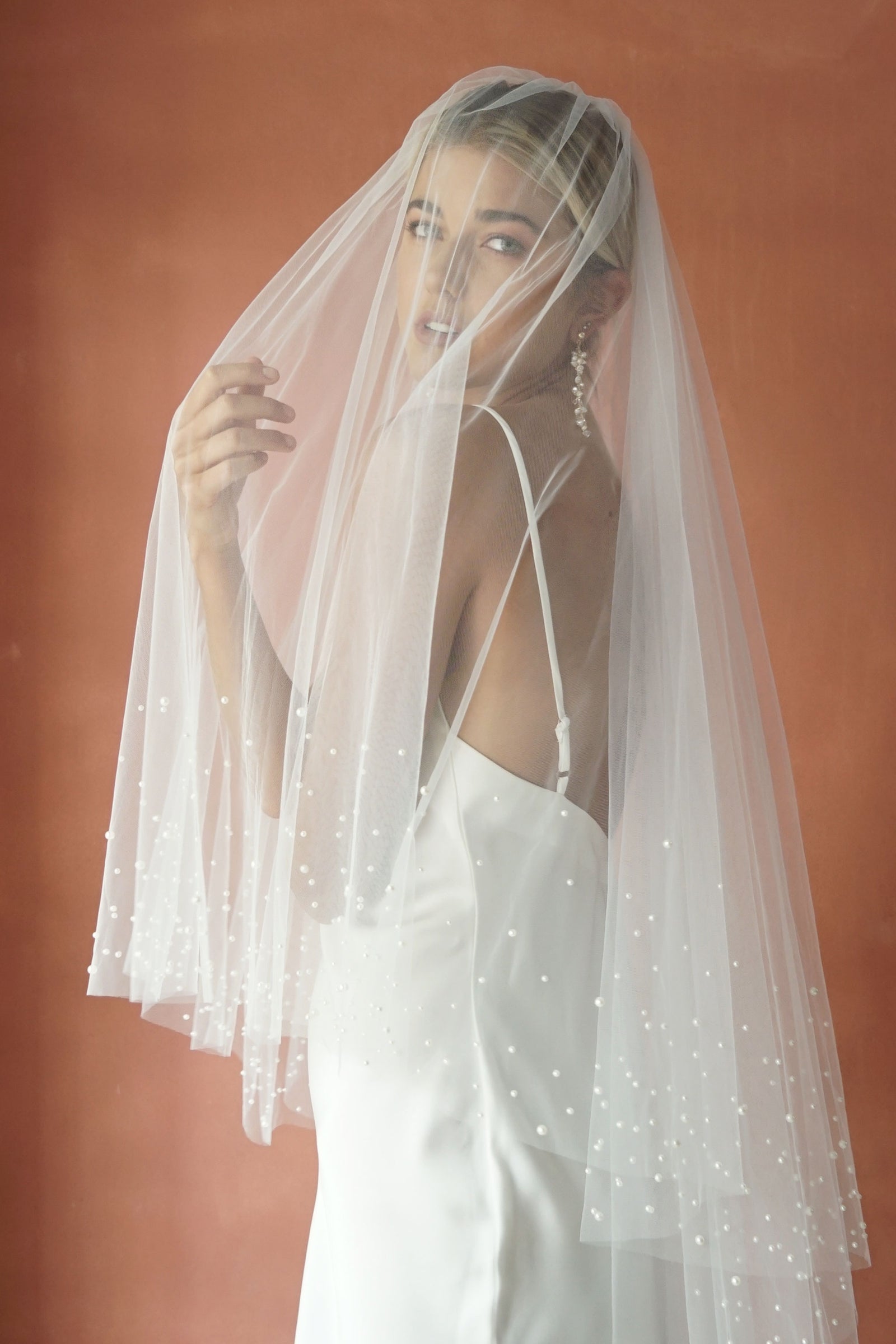 A model wearing ESTELLE, a two tier pearl wedding veil by Madame Tulle bridal