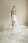 A model wearing a long one tier veil with embroidered text forever and ever