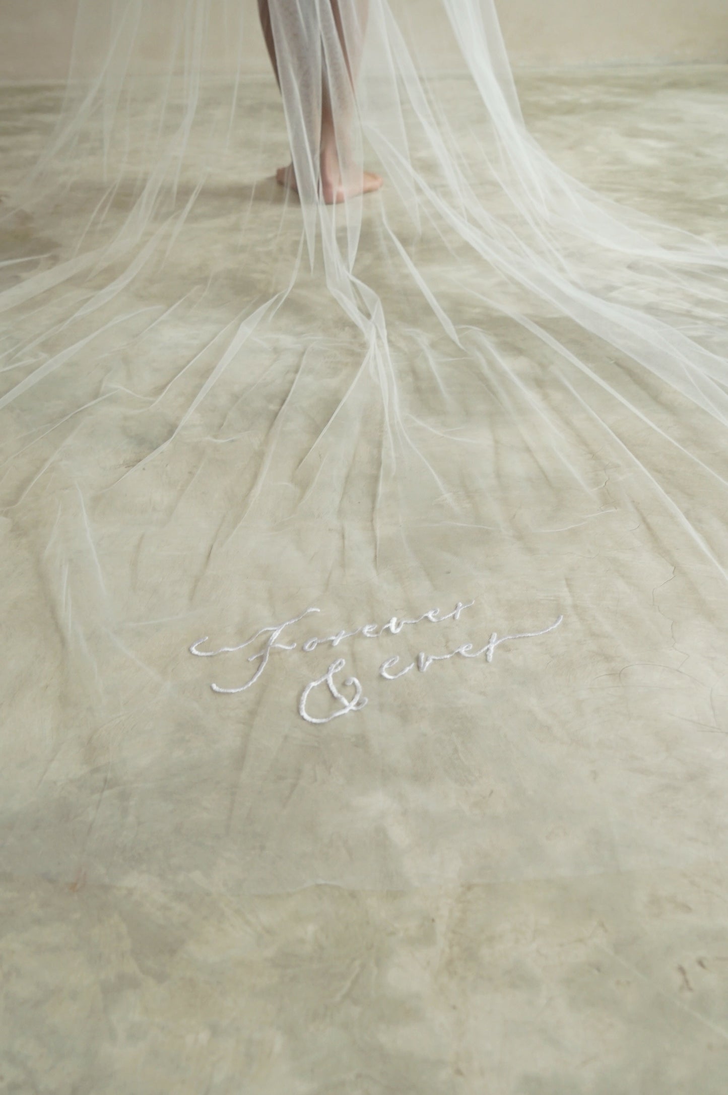 A long two tier veil with embroidered text forever and ever