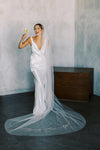 A model wearing embroidered wedding veil in cathedral length with text happily ever after
