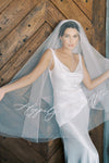 A model wearing embroidered wedding veil with text happily ever after