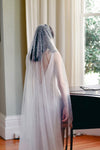 A model wearing MARIBEL I one tier pearl wedding veil by Madame Tulle