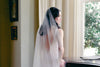 A model wearing MARIBEL I one tier pearl wedding veil by Madame Tulle