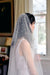 A model wearing MARIBEL I one tier pearl wedding veil by Madame Tulle