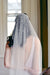 A model wearing MARIBEL I one tier pearl wedding veil by Madame Tulle