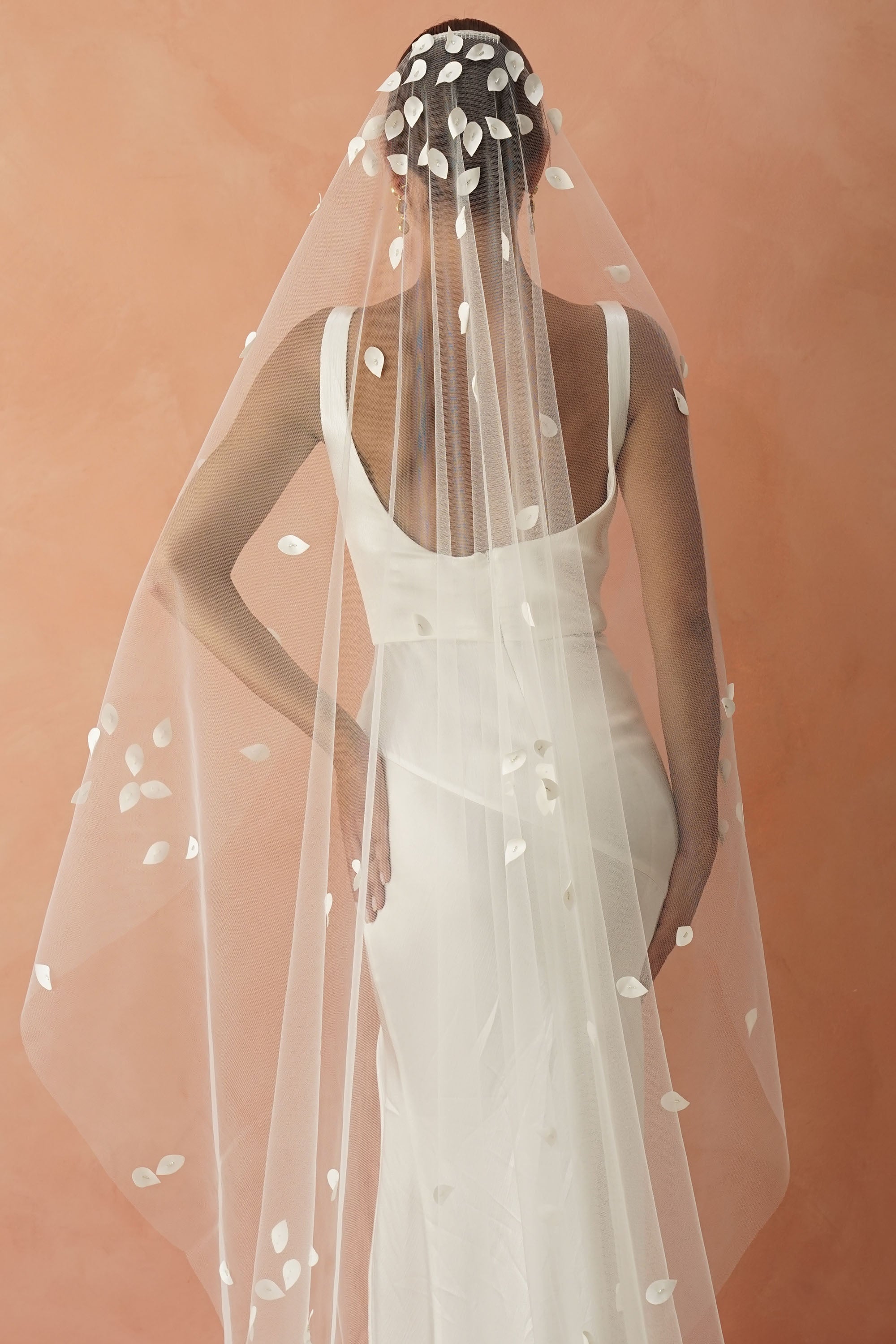 model wears a one-tier petal veil, wedding veil with satin petal and glass beads