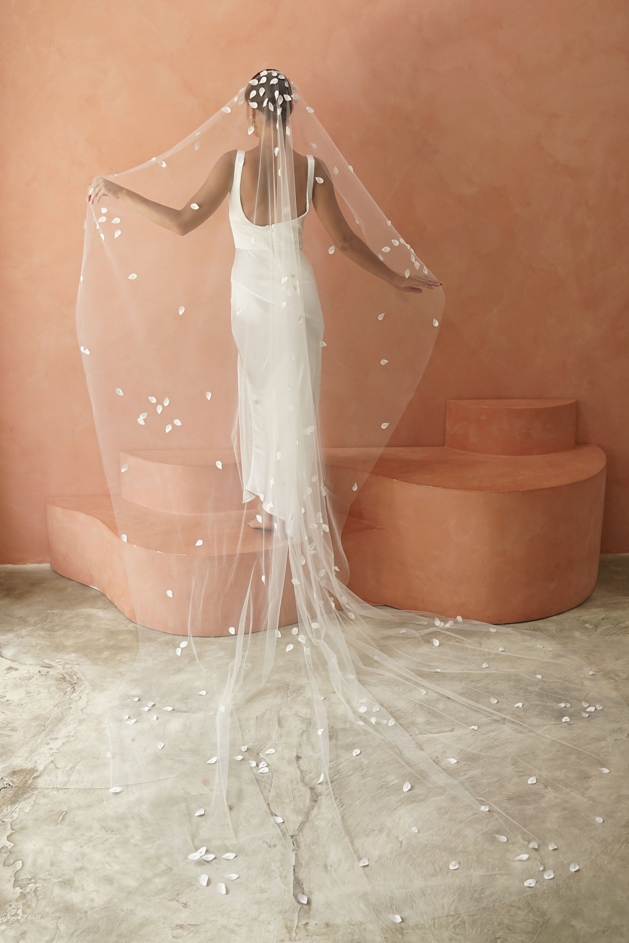 model wears a one-tier petal veil, wedding veil with satin petal and glass beads