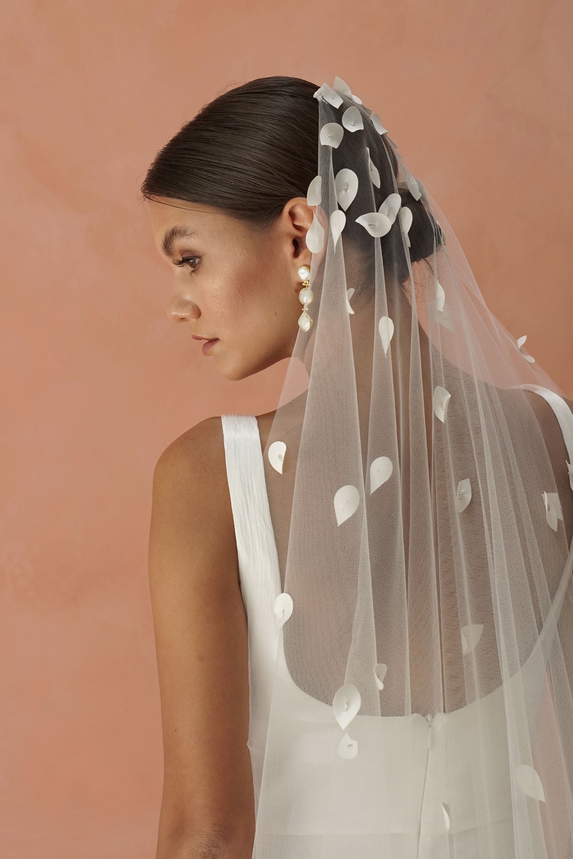 model wears a one-tier petal veil, wedding veil with satin petal and glass beads