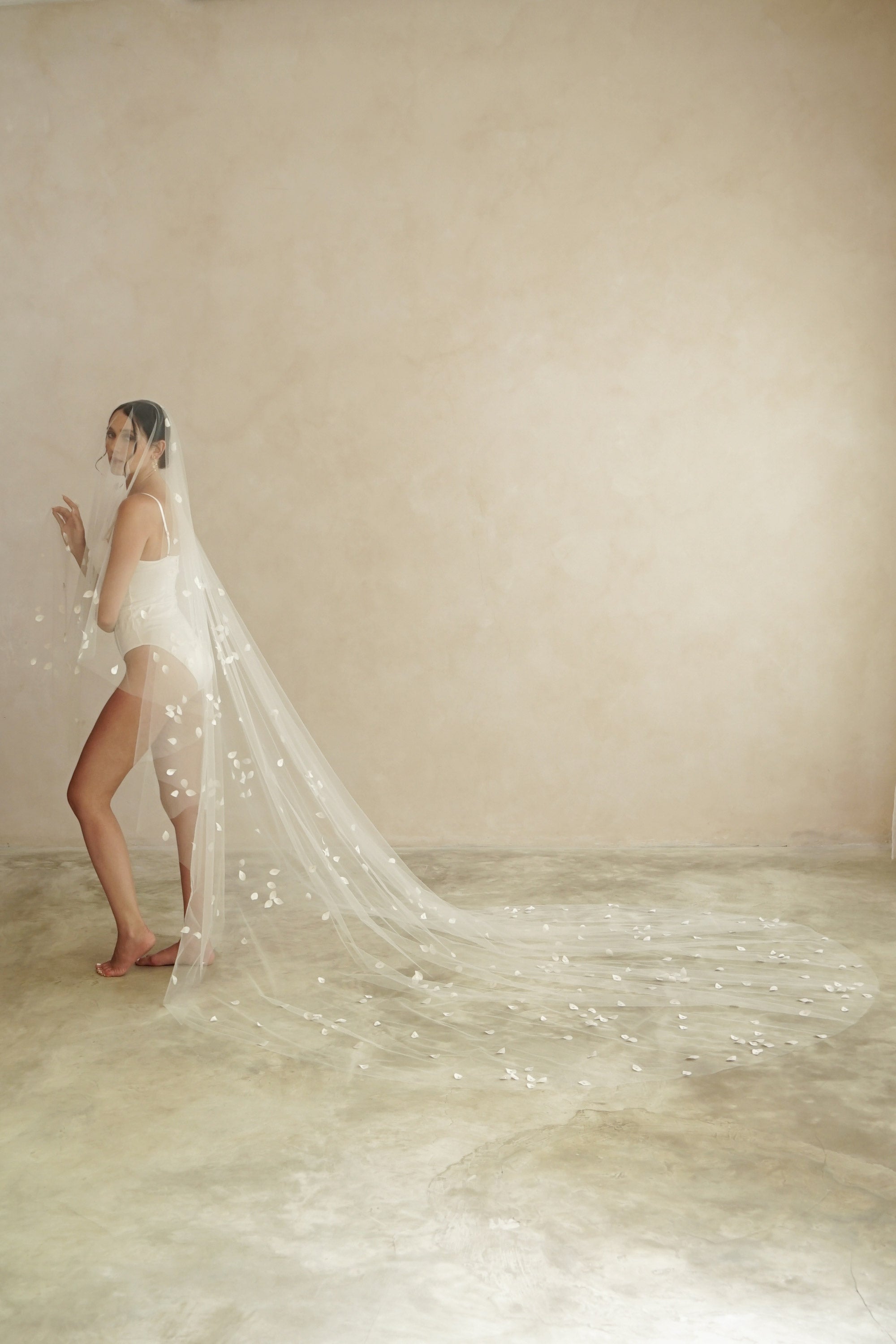 model wears a two-tier petal veil, drop veil with satin petal and glass beads