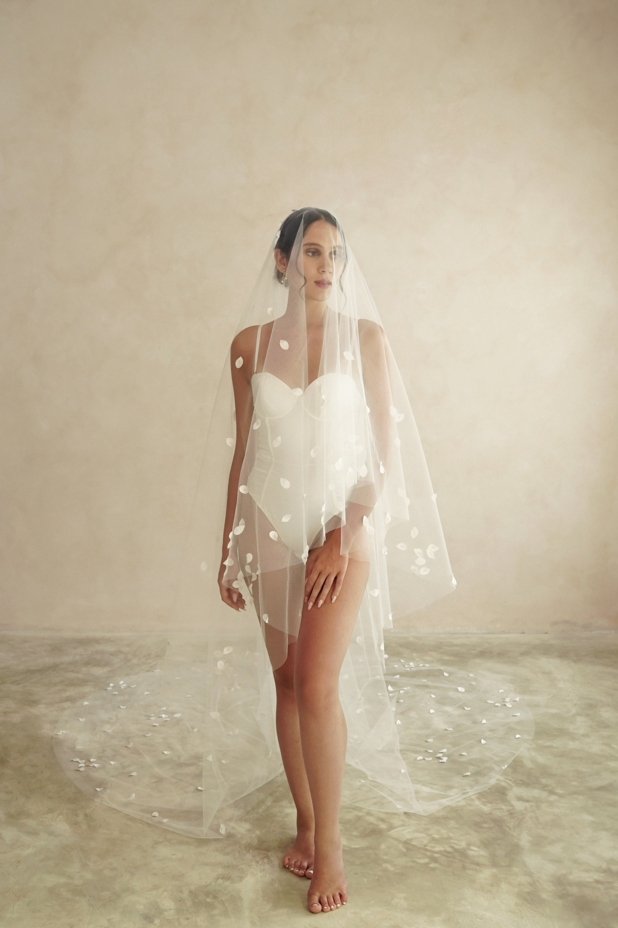 model wears a two-tier petal veil, drop veil with satin petal and glass beads
