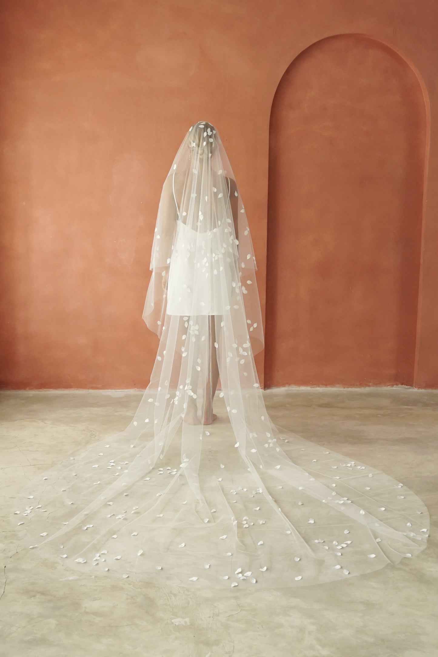 model wears a two-tier petal veil, drop veil with satin petal and glass beads