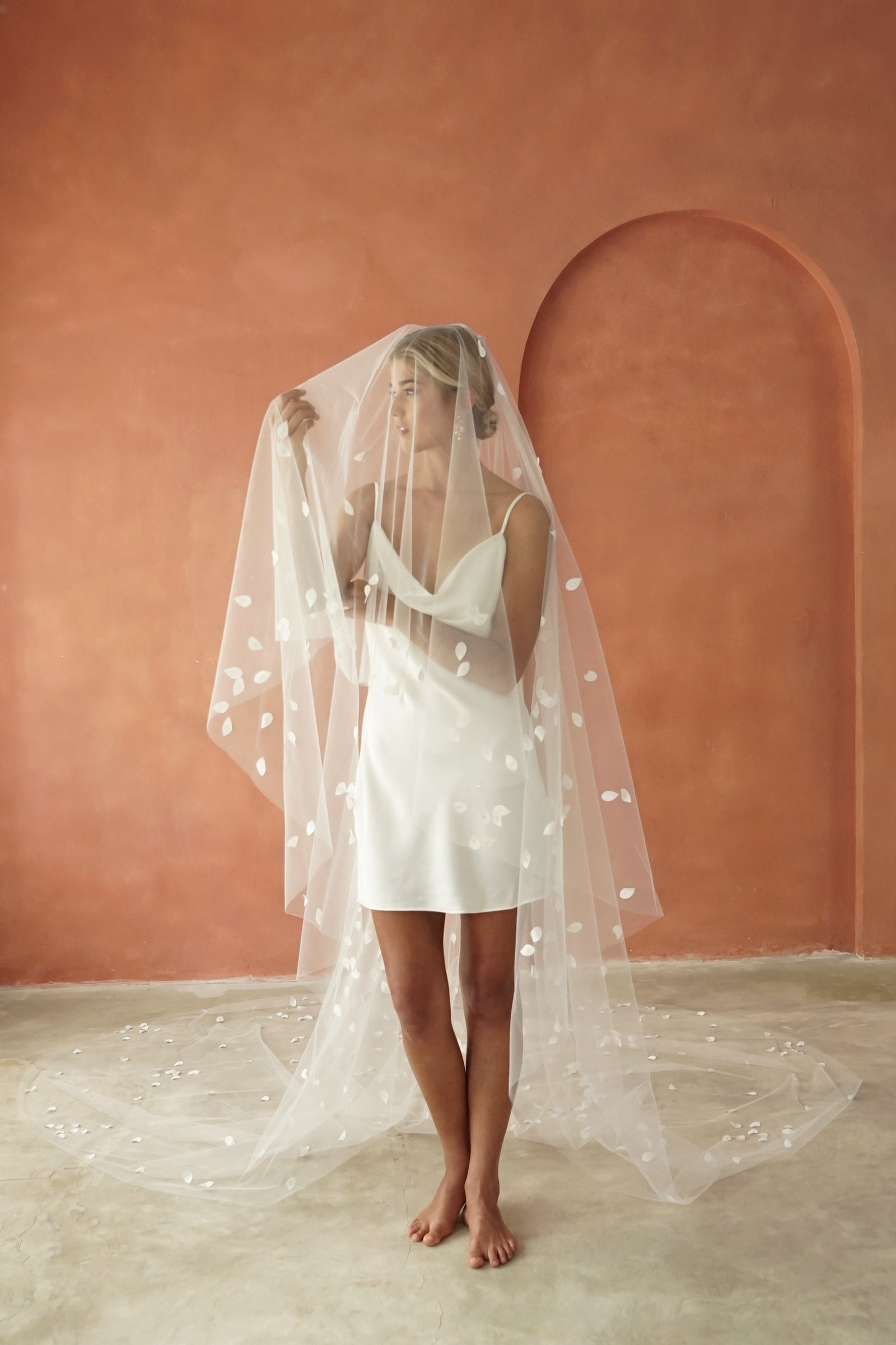 model wears a two-tier petal veil, drop veil with satin petal and glass beads