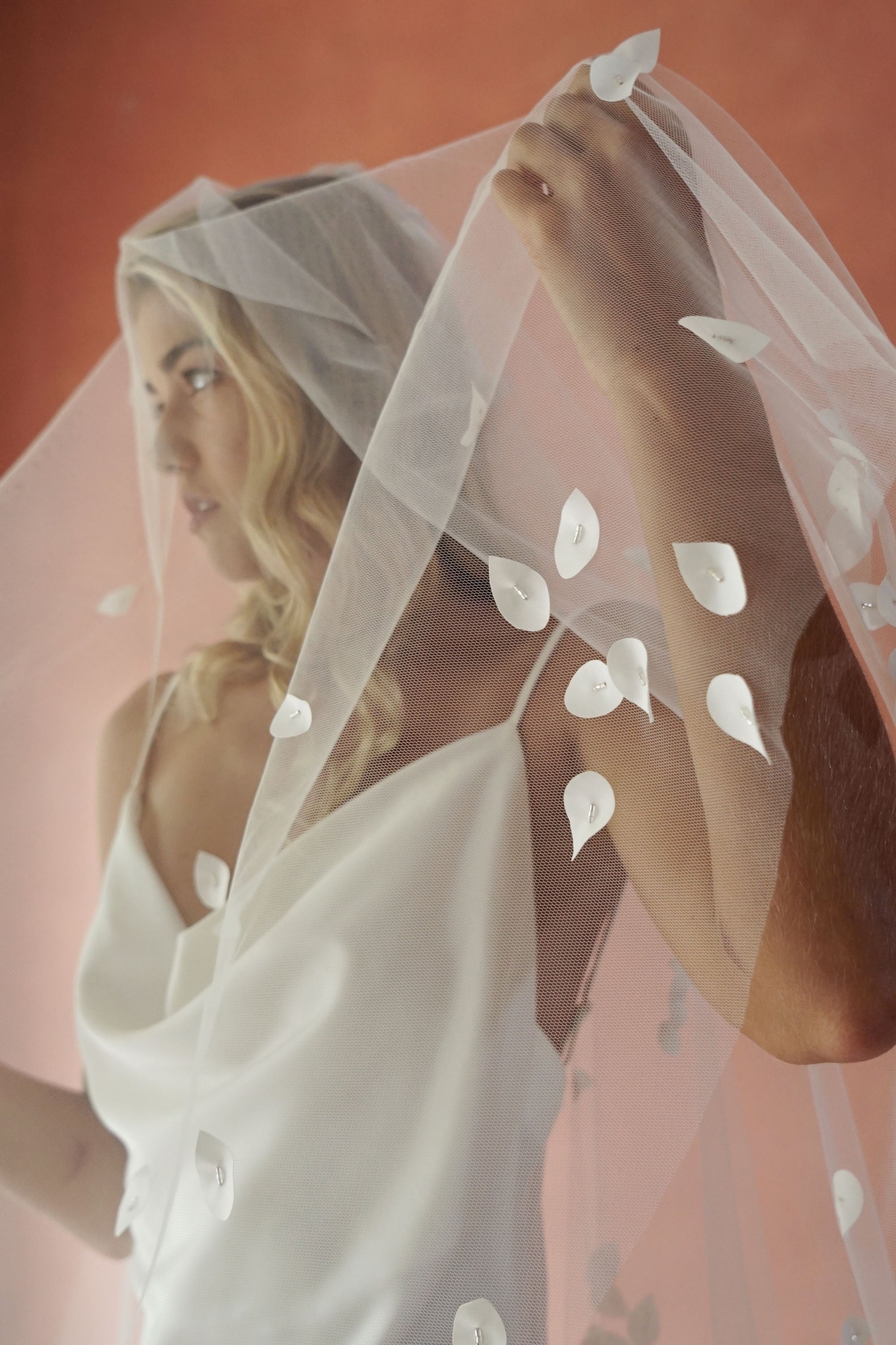 model wears a two-tier petal veil, drop veil with satin petal and glass beads