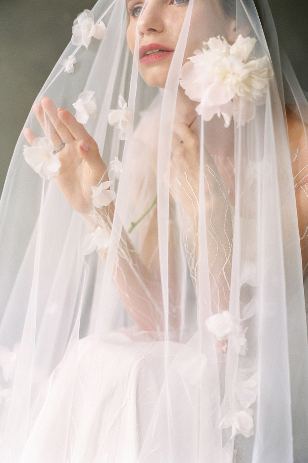 model wears a handmade three-dimensional fabric flowers wedding veil, floral veil