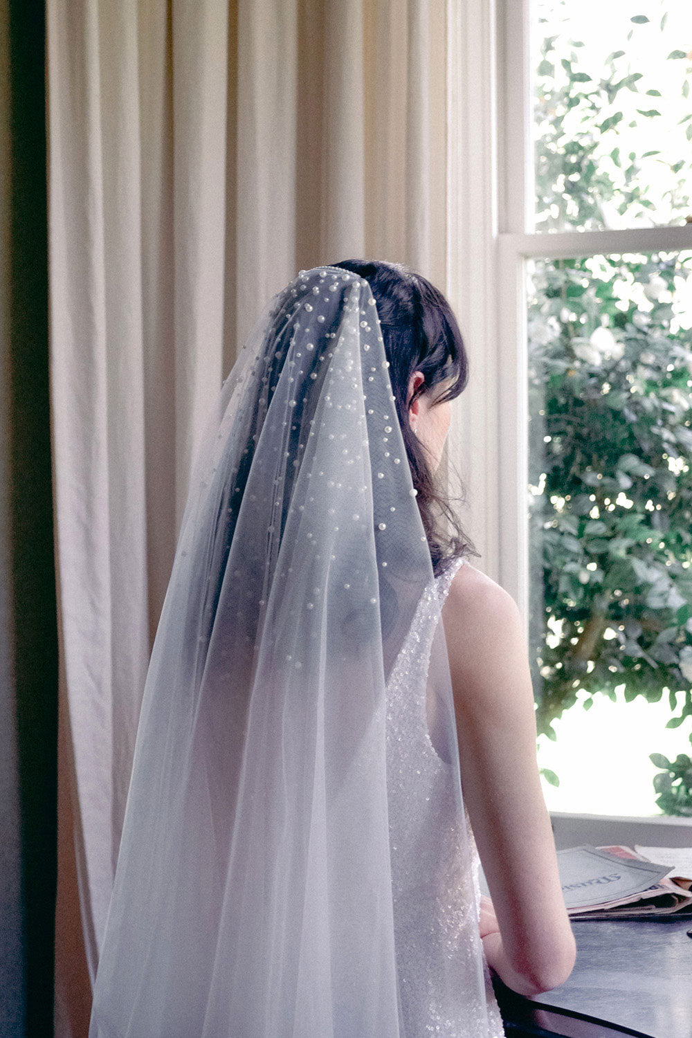 A model wearing MARIBEL II two tier pearl wedding veil by Madame Tulle