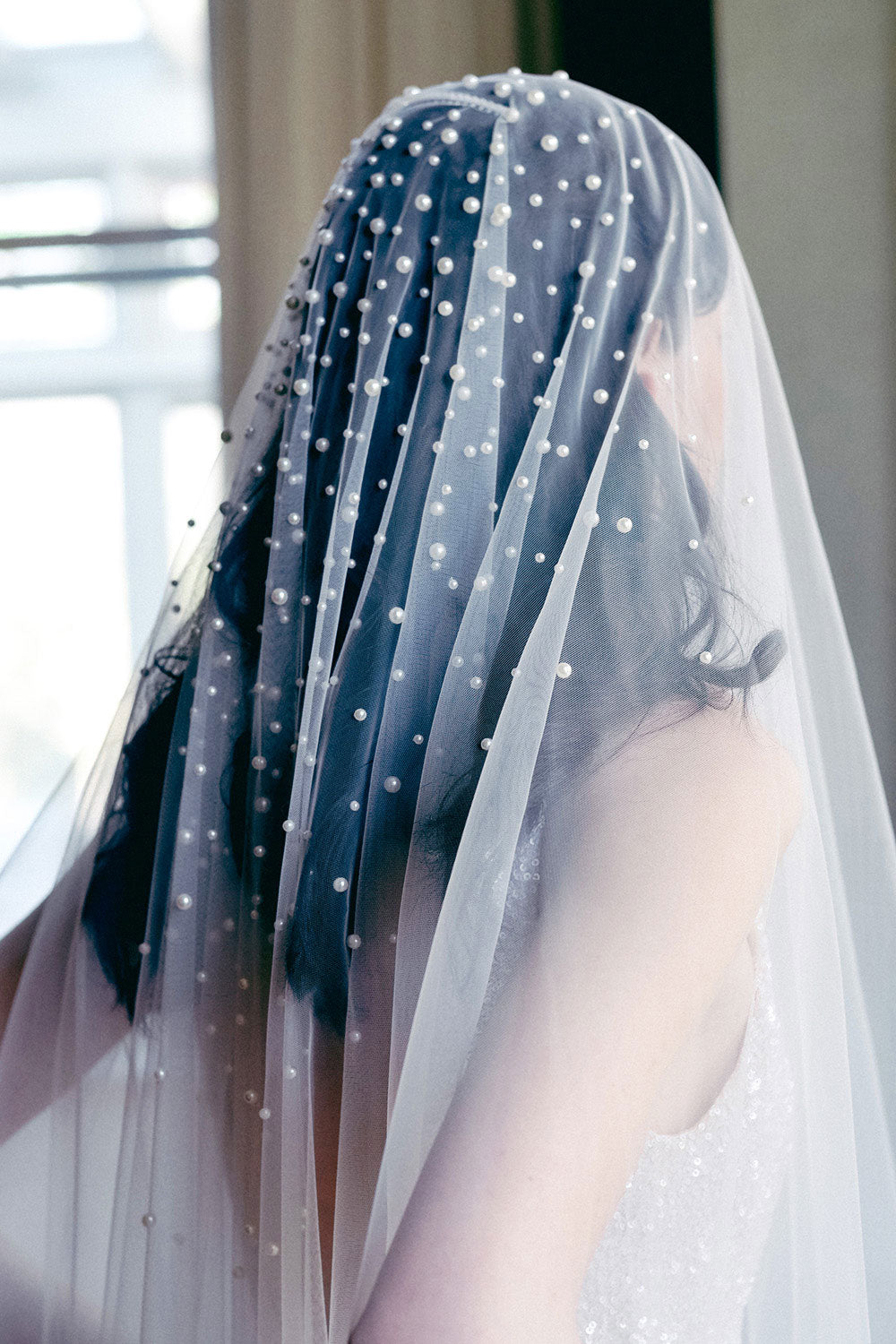 A model wearing MARIBEL II two tier pearl wedding veil by Madame Tulle