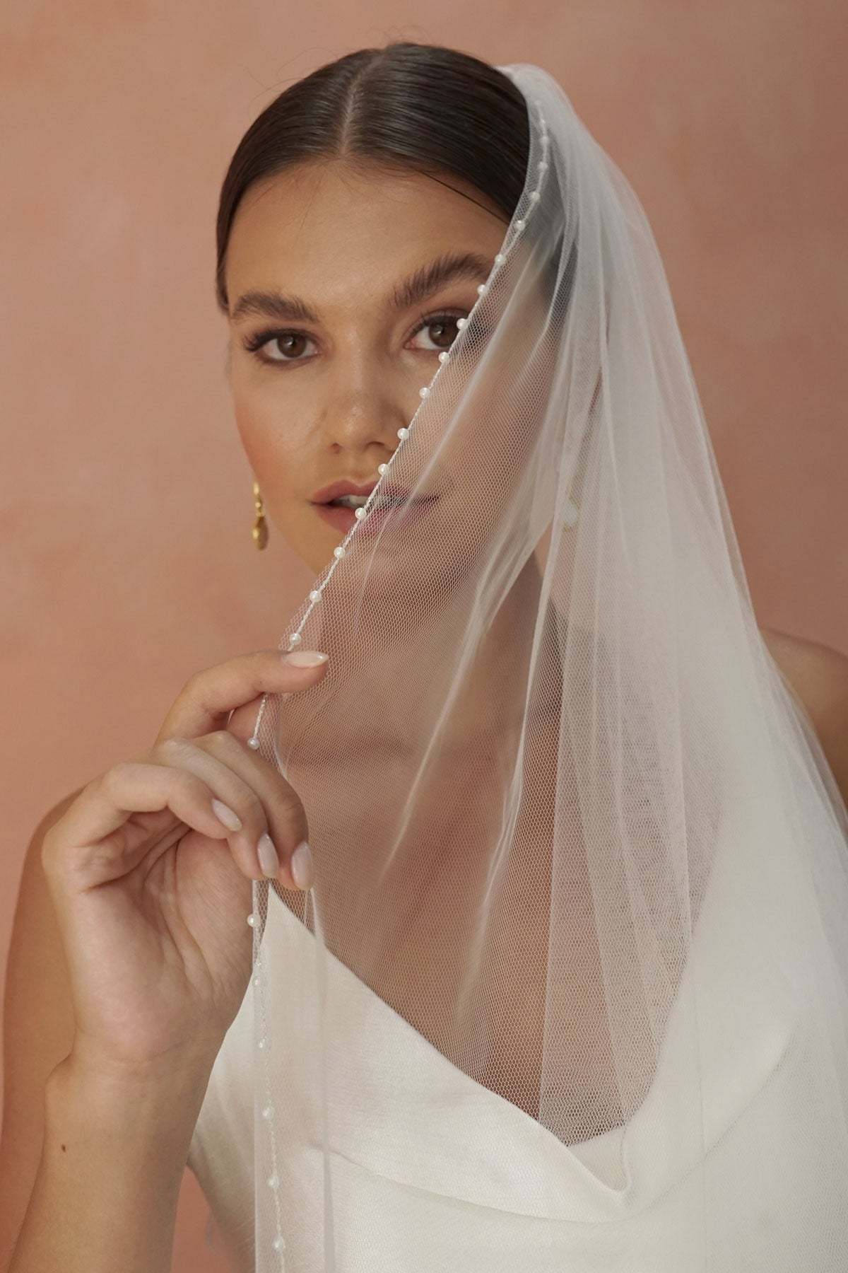 A model wearing a pearl edge wedding veil