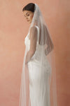 A model wearing a beaded pearl edge one tier wedding veil