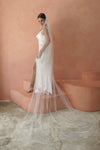 A model wearing a beaded pearl edge one tier wedding veil