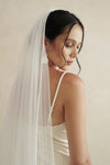 A model wearing a one tier satin cord edge wedding veil