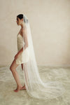 A model wearing a one tier satin cord edge wedding veil