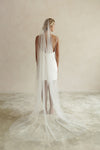 A model wearing the ELLA I minimalist one tier wedding veil in chapel length ivory colour
