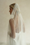 A model wearing the CHLOE one tier wedding veil with small pearls