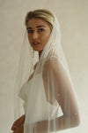 A model wearing the CHLOE one tier wedding veil with small pearls