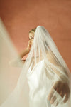A model wearing the CHLOE one tier wedding veil with small pearls