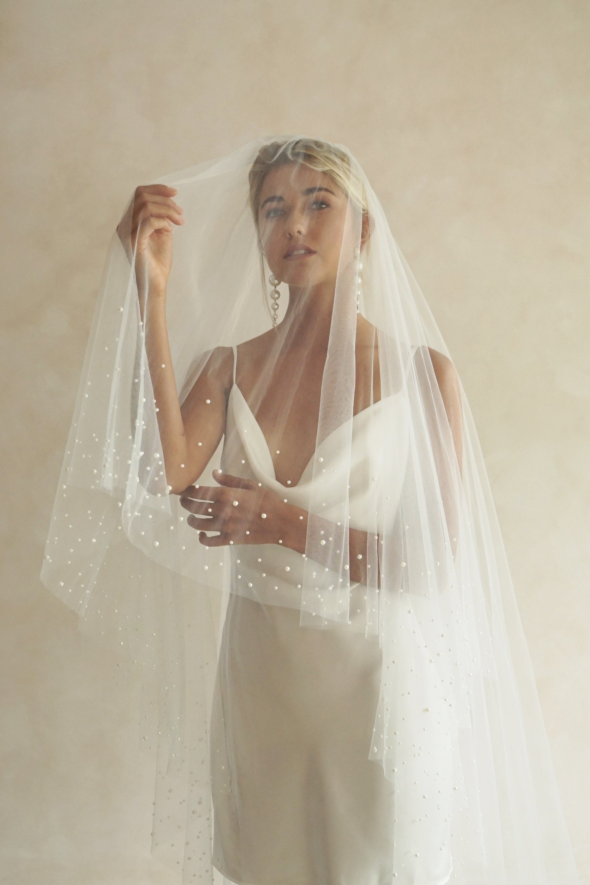 A model wearing ESTELLE, a two tier pearl wedding veil by Madame Tulle bridal