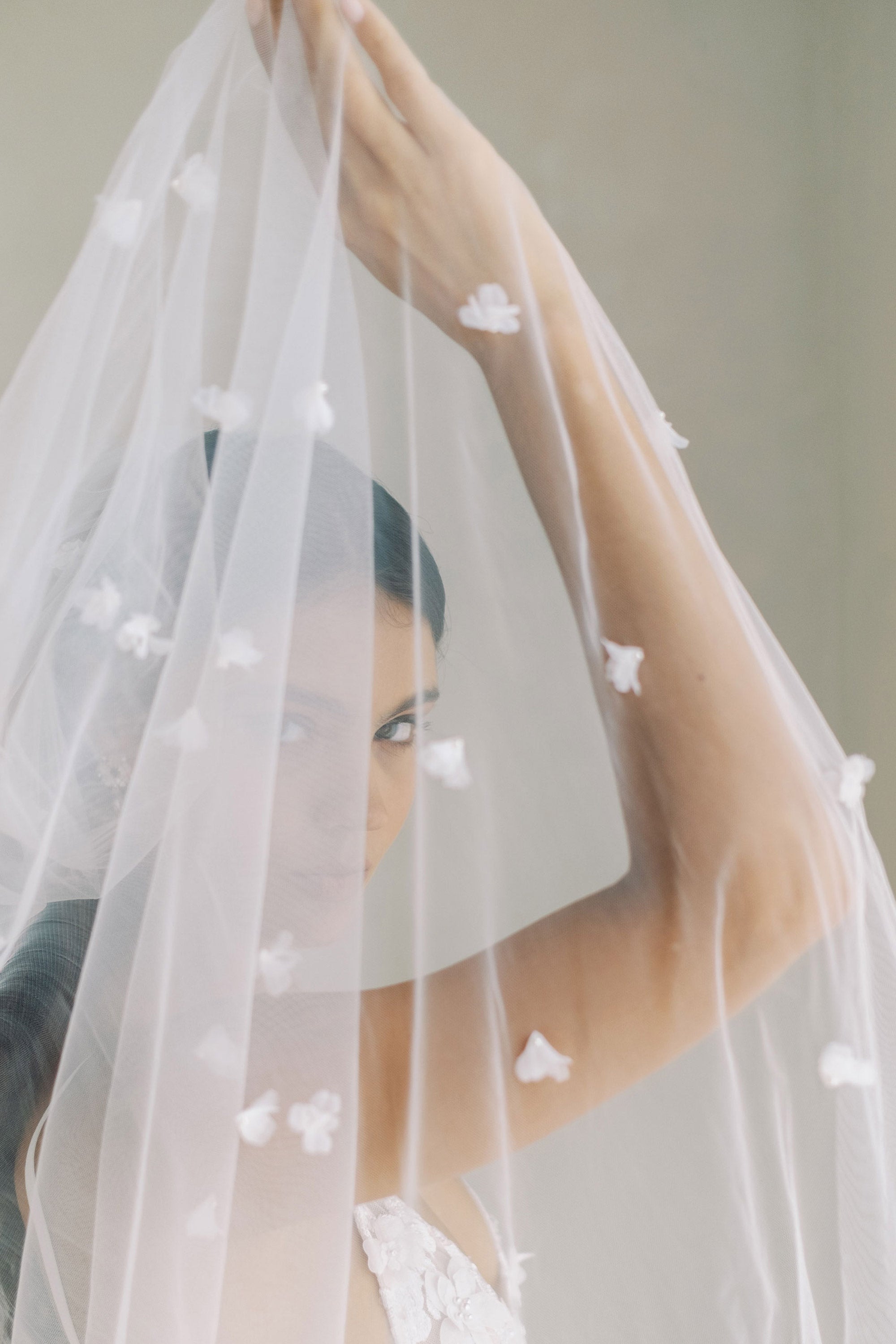 model wears wedding veil with small flowers and tiny pearls, single-tier floral veil