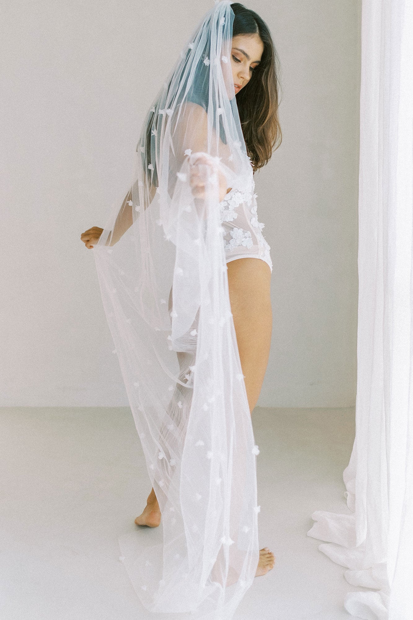 model wears wedding veil with small flowers and tiny pearls, single-tier floral veil