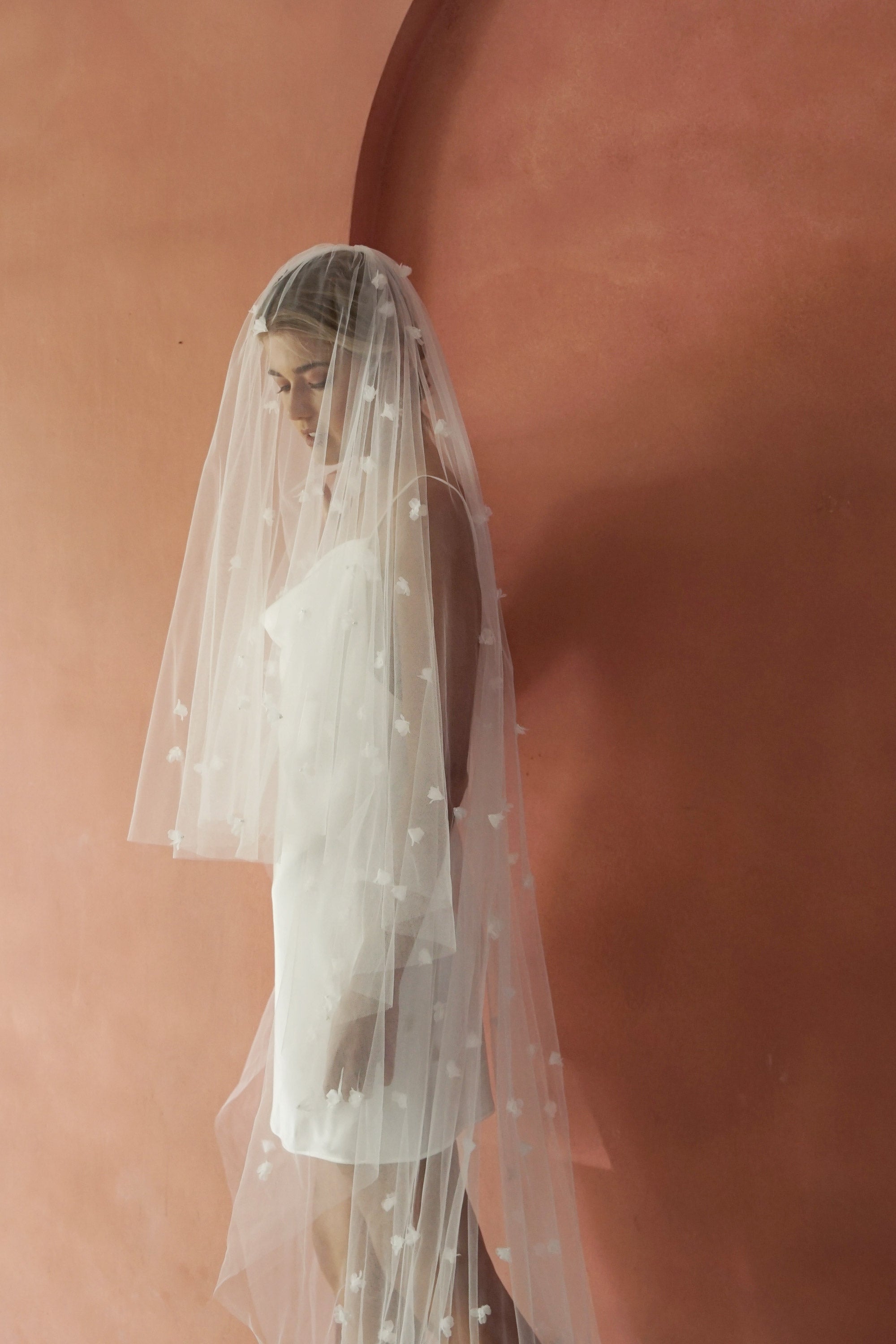 model wears wedding veil with small flowers and tiny pearls, floral drop veil