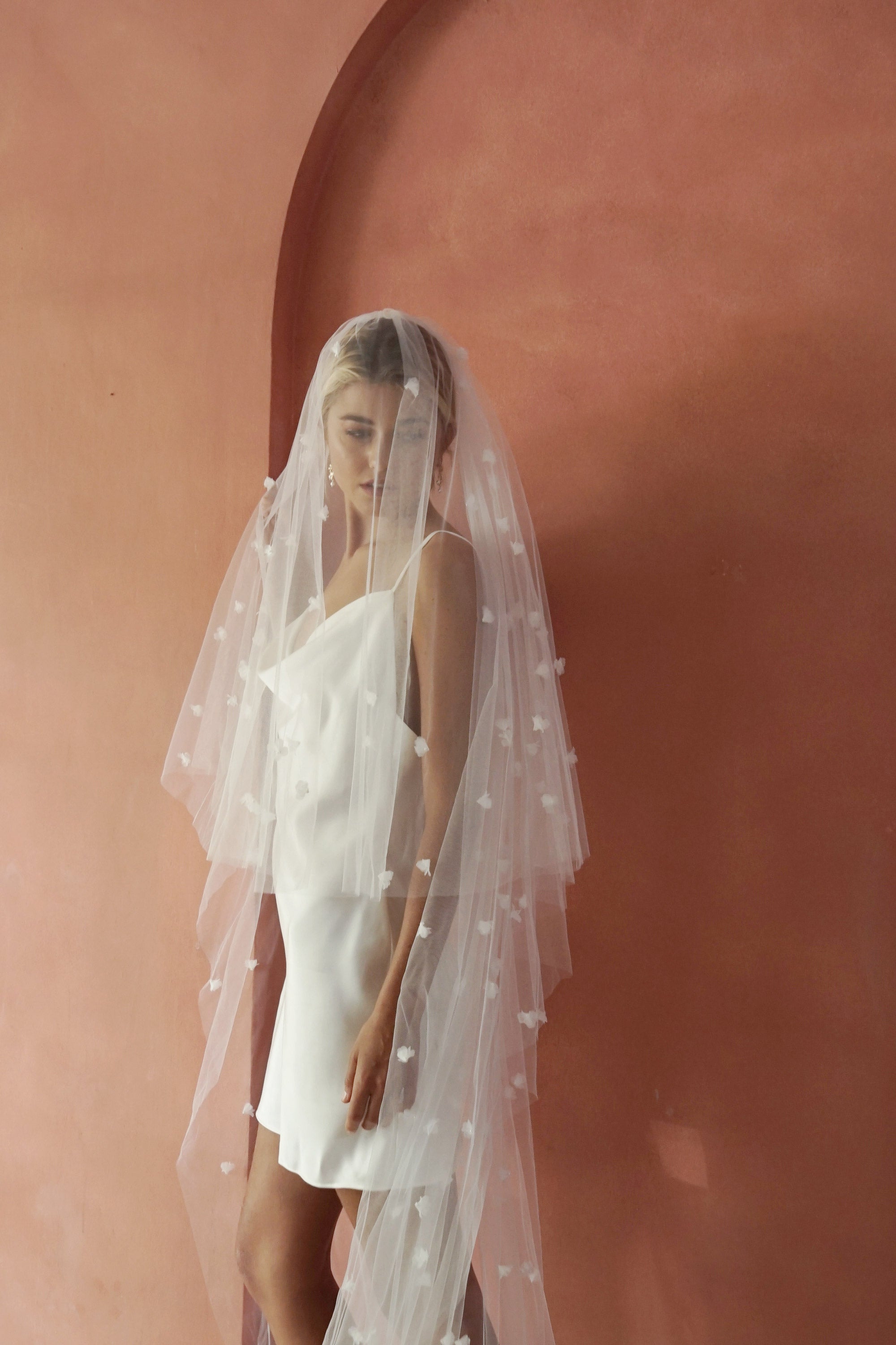 model wears wedding veil with small flowers and tiny pearls, floral drop veil