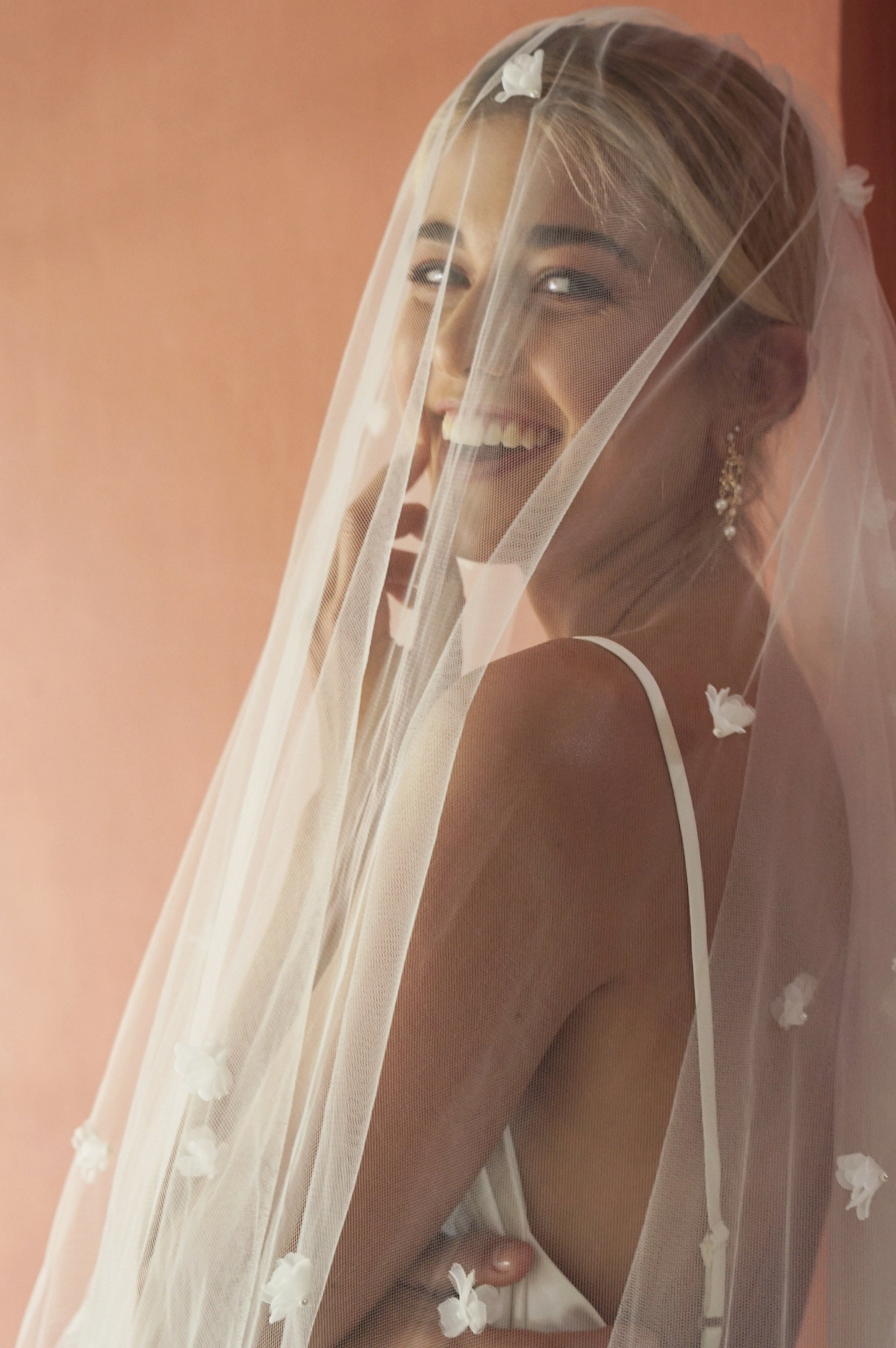 model wears wedding veil with small flowers and tiny pearls, floral drop veil