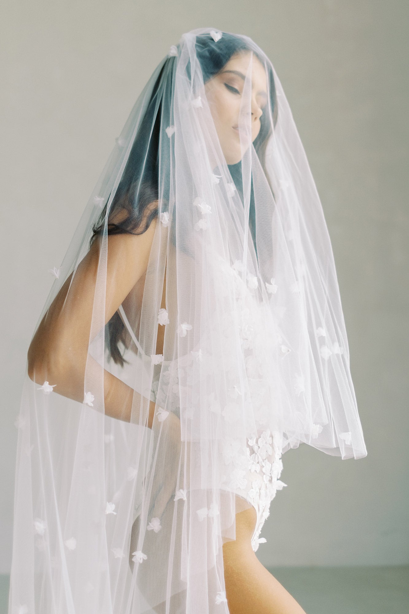 model wears wedding veil with small flowers and tiny pearls, floral drop veil