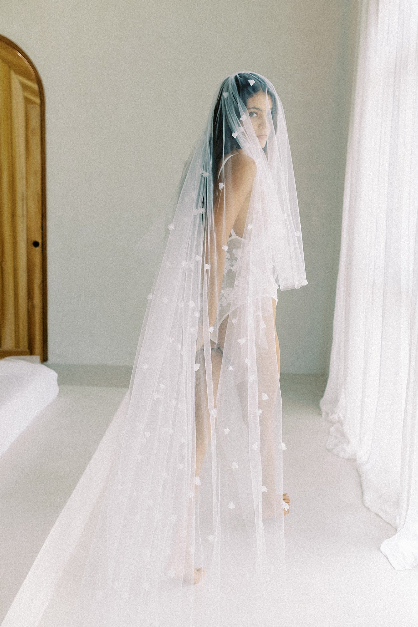 model wears wedding veil with small flowers and tiny pearls, floral drop veil