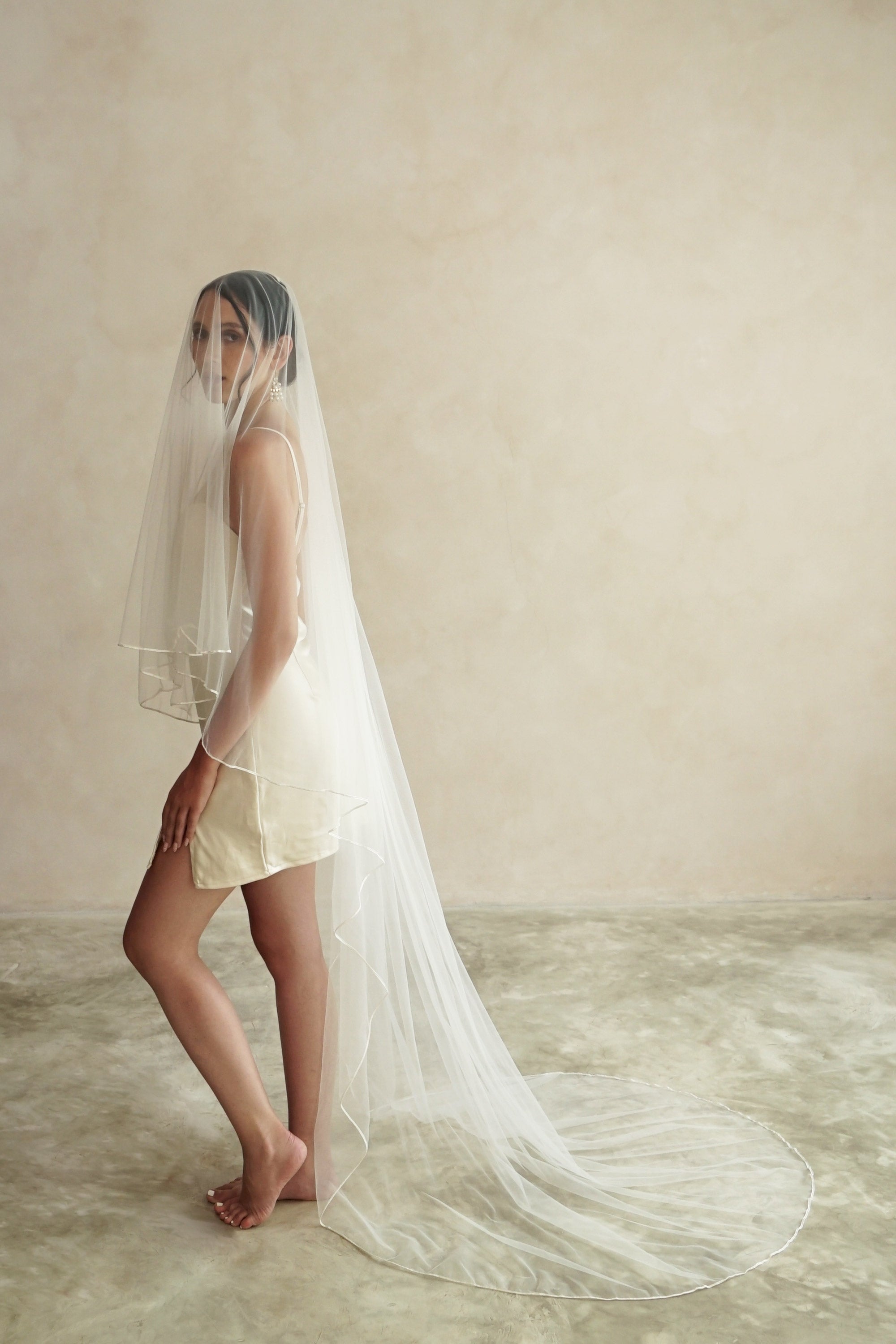 A model wearing a two tier satin cord edge wedding veil