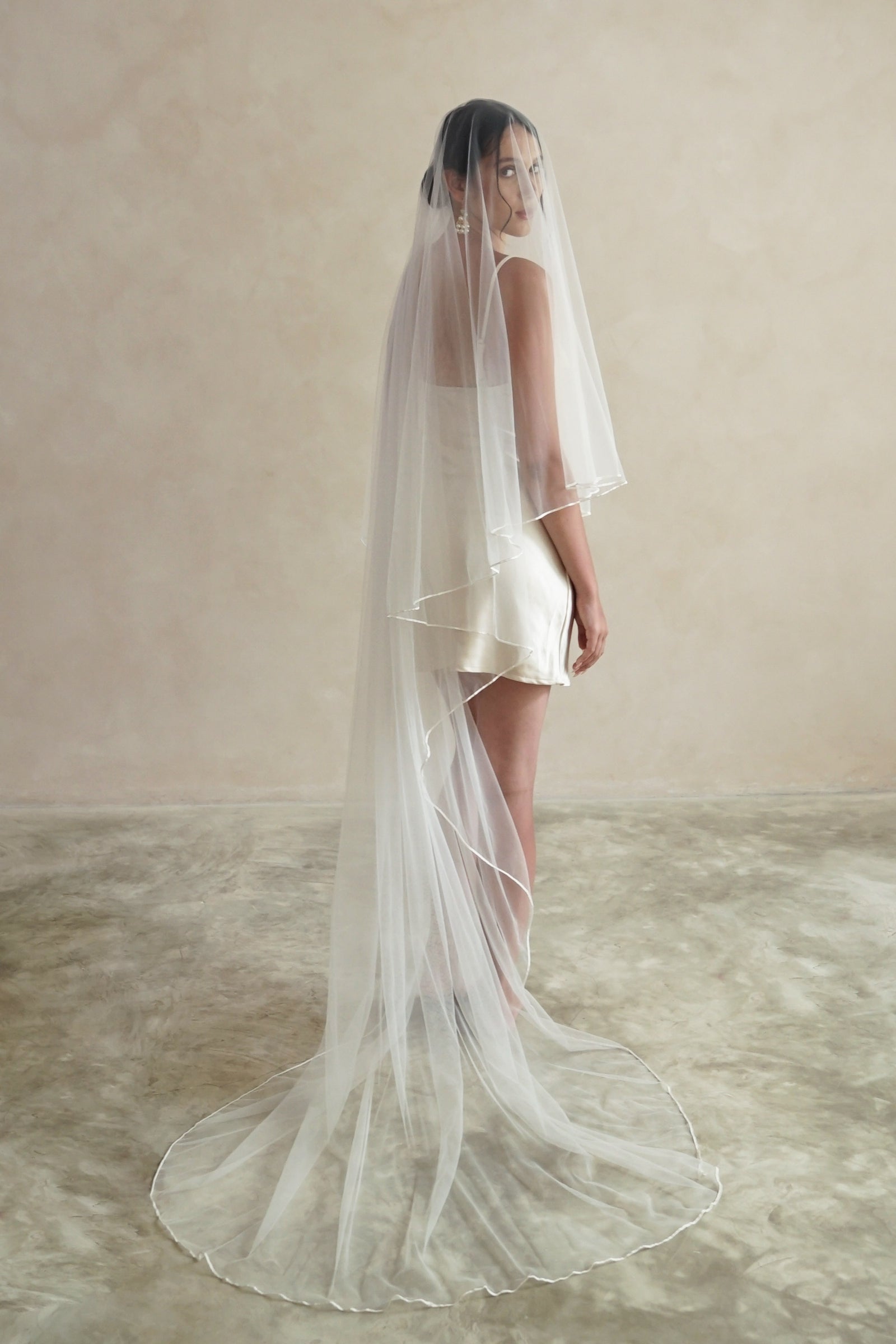 A model wearing a two tier satin cord edge veil
