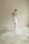 A model wearing a long wedding veil with embroidery text that&#39;s amore