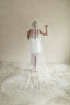 A model wearing a long wedding veil with embroidery text that&#39;s amore