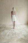 A model wearing a long wedding veil with embroidery text that&#39;s amore