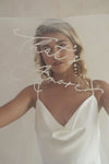 A model wearing a long wedding veil with embroidery text that&#39;s amore