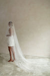 A model wearing a long wedding veil with embroidery text that&#39;s amore