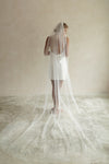 A model wearing a long wedding veil with embroidery together forever