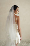 A model wearing a two tier satin cord edge wedding veil